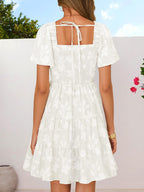 Women's smocked tiered square neck short sleeve casual dress with pockets, featuring a relaxed fit and stylish design.
