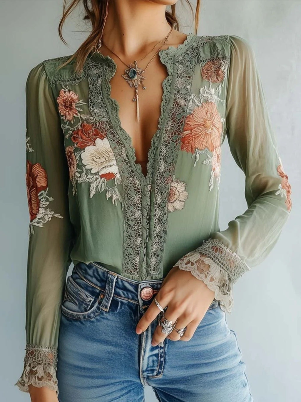 Elegant floral lace blouse by Trendsi featuring long sleeves and a sophisticated feminine design.