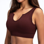 Dark brown ribbed sports bra with a U-neckline and notched detail on a model.