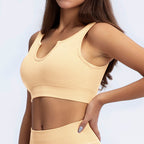Pale peach ribbed sports bra with a notched v-neckline and matching high-waist athletic bottoms.