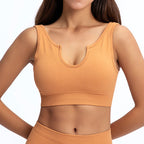 Mustard-yellow ribbed sports bra with a U-shaped notched neckline and a comfortable, seamless fit.