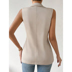 Back view of a sleeveless beige tailored vest with a collared neckline, worn with blue jeans.