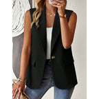A woman wears a sleeveless black blazer vest with notched lapels and a single-button closure over a white top.