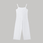Minimalist white spaghetti strap jumpsuit with a wide-leg silhouette against a plain grey background.