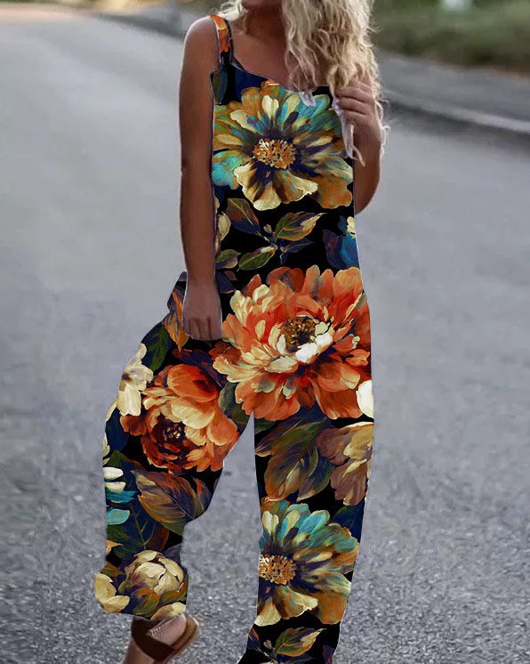 Woman wearing a black sleeveless jumpsuit with a vibrant, large orange and teal floral print.