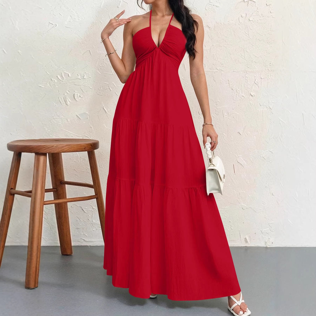A woman wears a vibrant red, floor-length halter maxi dress with a deep v-neck and a tiered, flowing skirt.