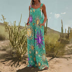 Green wide-leg jumpsuit with sun and star print, button straps, and side pockets, worn in a desert setting.