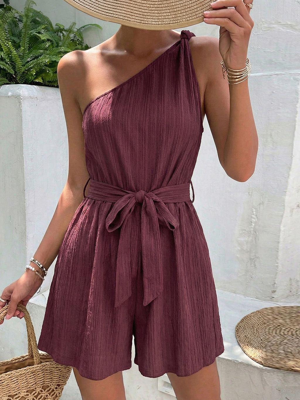 Elegant one-shoulder tie-waist romper in premium polyester, stylish summer jumpsuit by Trendsi, shown in a vibrant outdoor setting.