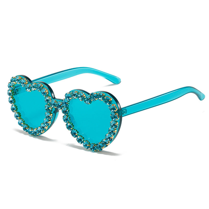 Teal heart-shaped sunglasses with matching crystal-encrusted rims on a white background.