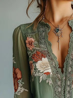 Elegant floral lace blouse by Trendsi featuring long sleeves and sophisticated feminine design, shown in a detailed front view.