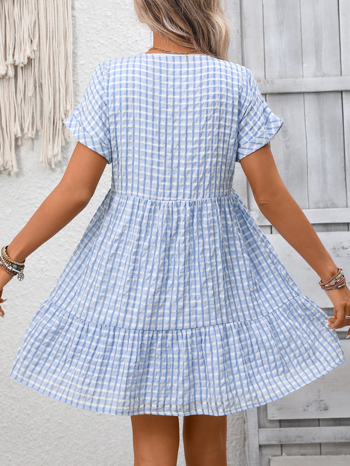 Lightweight plaid V-neck mini dress with ruffle hem from Trendsi, perfect for seasonal fashion, shown in a stylish dress image.