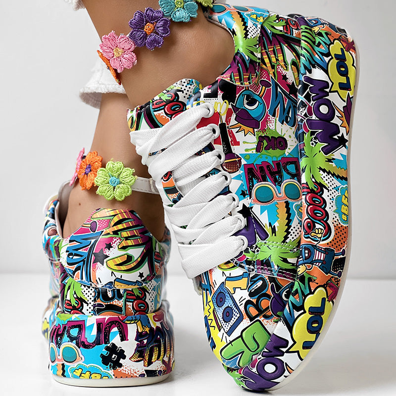 Colorful pop-art print sneakers with white laces and a vibrant, multi-colored floral anklet on a person's foot.