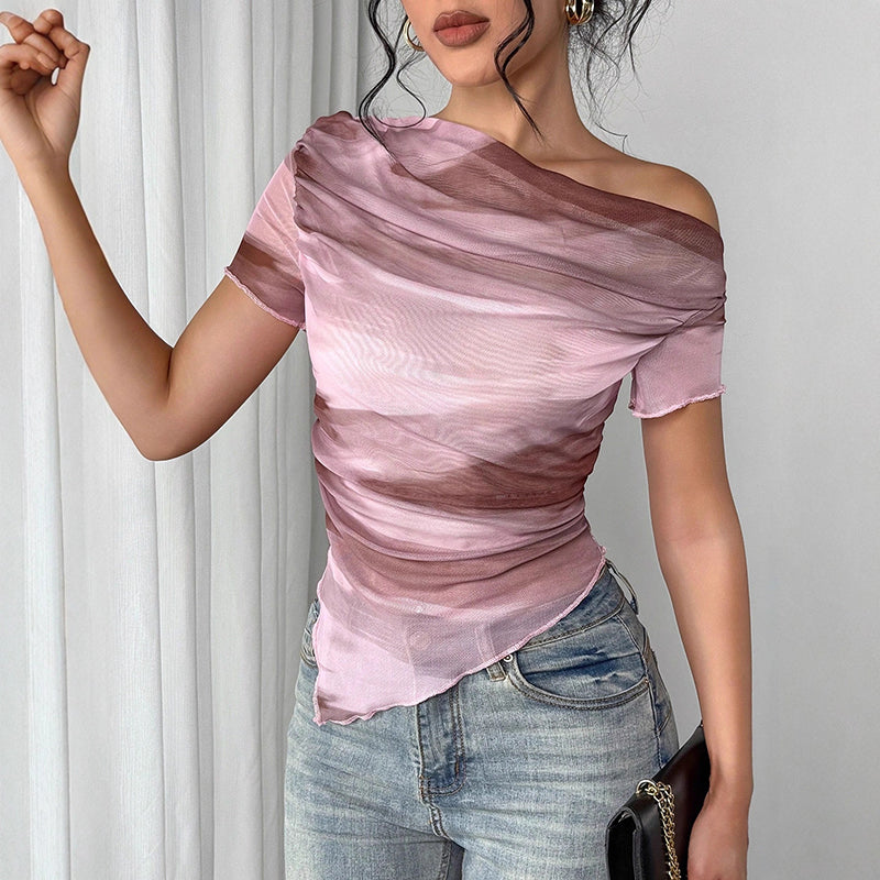A woman wearing a pink and brown tie-dye sheer, asymmetric off-shoulder top with short sleeves and a raw hem.