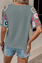 Geometric print round neck short sleeve blouse from Trendsi, featuring a stylish design with a modern geometric pattern.