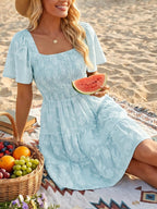 Women's smocked tiered square neck short sleeve casual dress with pockets, stylish and comfortable from Trendsi.
