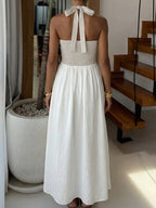 Elegant two-tone halter neck maxi dress with ruched details and pockets, perfect for stylish occasions.