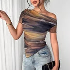 Asymmetrical off-the-shoulder mesh top in a brown, gold, and grey abstract watercolor print with a ruched finish.