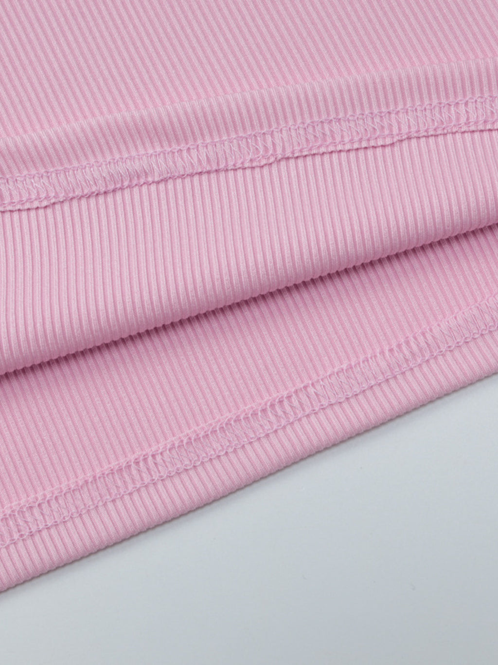 Women's ribbed knit button-front long sleeve T-shirt from Trendsi, shown in a close-up of the soft fabric and stylish design.