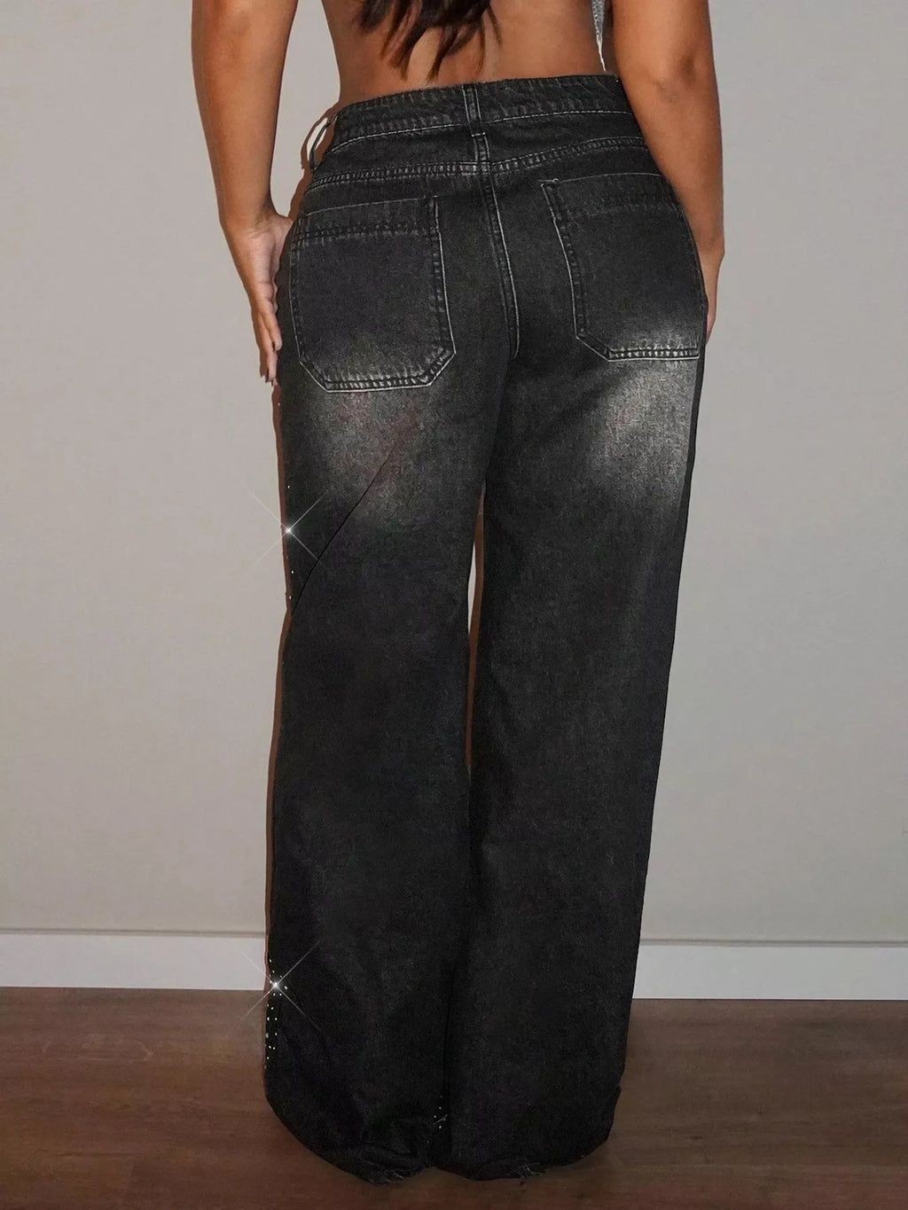 Rhinestone wide-leg jeans by Trendsi featuring embellishments along the pockets and a relaxed fit, styled with a casual top.