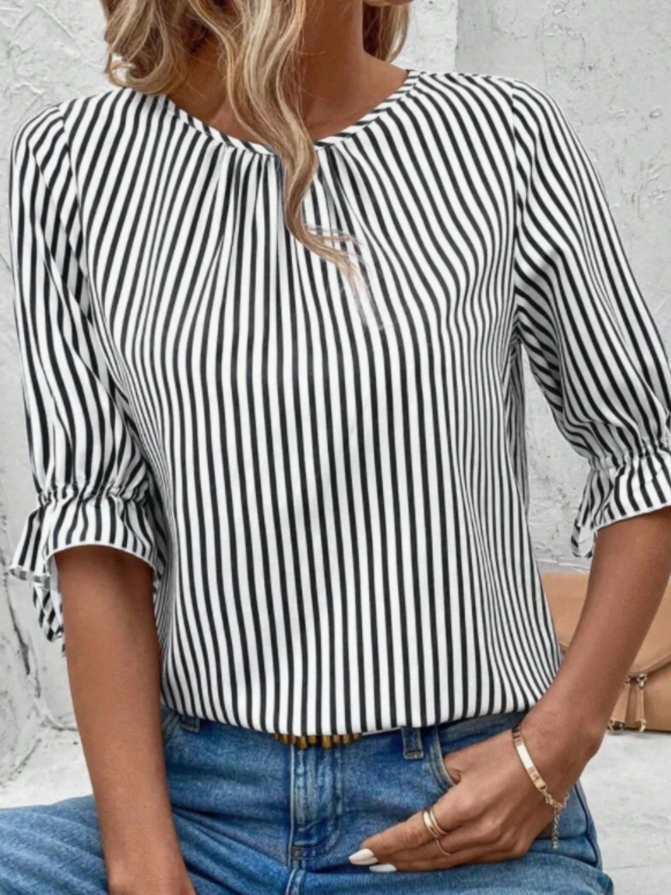 Women's striped ruffled round neck half sleeve blouse from Trendsi, featuring a stylish design with ruffles and a classic round neckline.