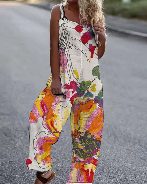 Woman wearing a sleeveless, wide-leg jumpsuit with a cream background and colorful abstract floral print.