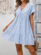 Lightweight plaid V-neck mini dress with ruffle hem from Trendsi, perfect for seasonal fashion and casual wear.
