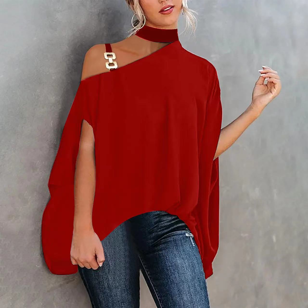 Red one-shoulder tunic with choker neck, metallic gold hardware detail, and loose, split-sleeve design.