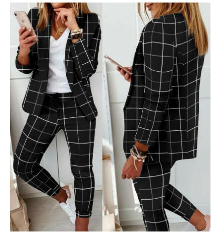 Woman in a black blazer and matching trousers with a white grid pattern, worn over a plain white v-neck t-shirt.