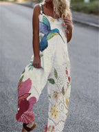 Cream-colored sleeveless jumpsuit with a large blue hummingbird and floral print in pink, yellow, and green.