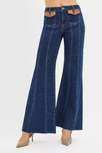High-rise wide flare jeans with leather pocket details from Trendsi, showcasing the stylish denim design and contrasting leather accents.