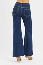 High-rise wide flare jeans with leather pocket details by Trendsi, showcasing the stylish denim design and unique pocket accents.