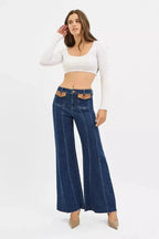 High-rise wide flare jeans by Trendsi with leather pocket details, showcasing a stylish denim look and modern design.