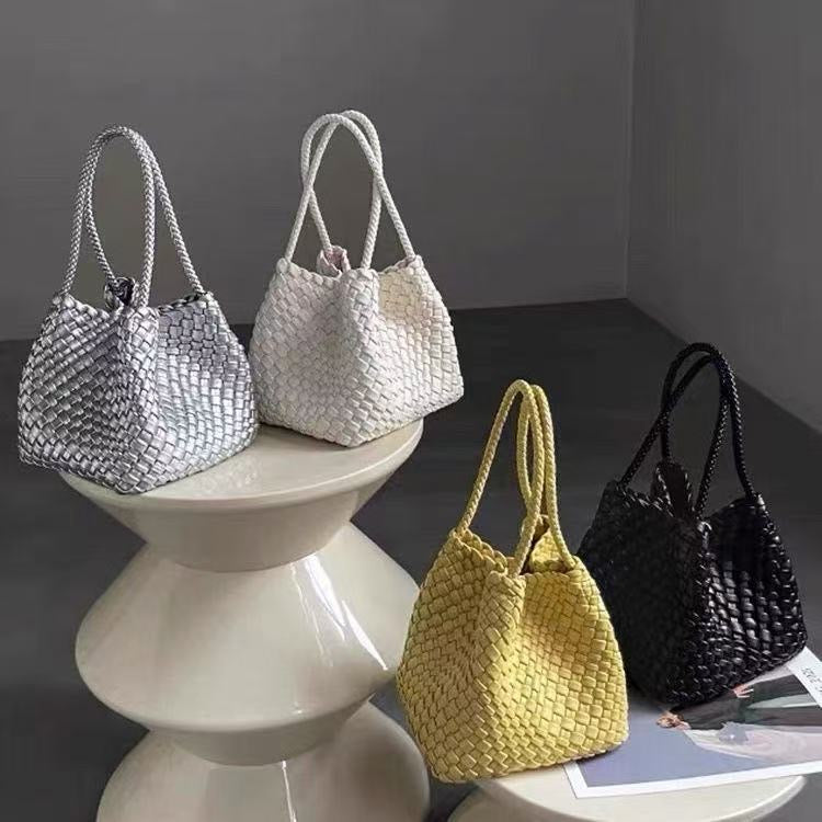 Four woven, bucket-style handbags with rope handles in metallic silver, white, bright yellow, and black.
