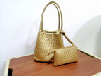 Metallic gold woven leather bucket bag and matching rectangular zippered pouch on a wood surface.