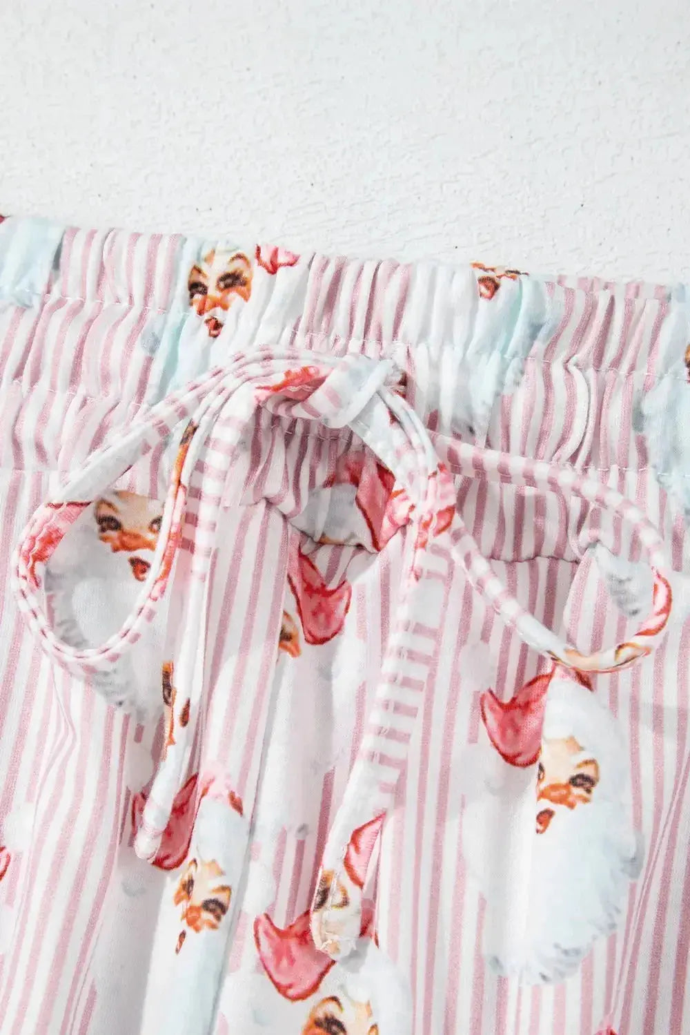 Women's festive Santa print long sleeve pajama lounge set by Trendsi, featuring cozy holiday-themed sleepwear with red and white details.