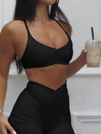 Women wearing a Trendsi activewear set with a ruched sports bra and high-waisted shorts, perfect for workout and casual wear.