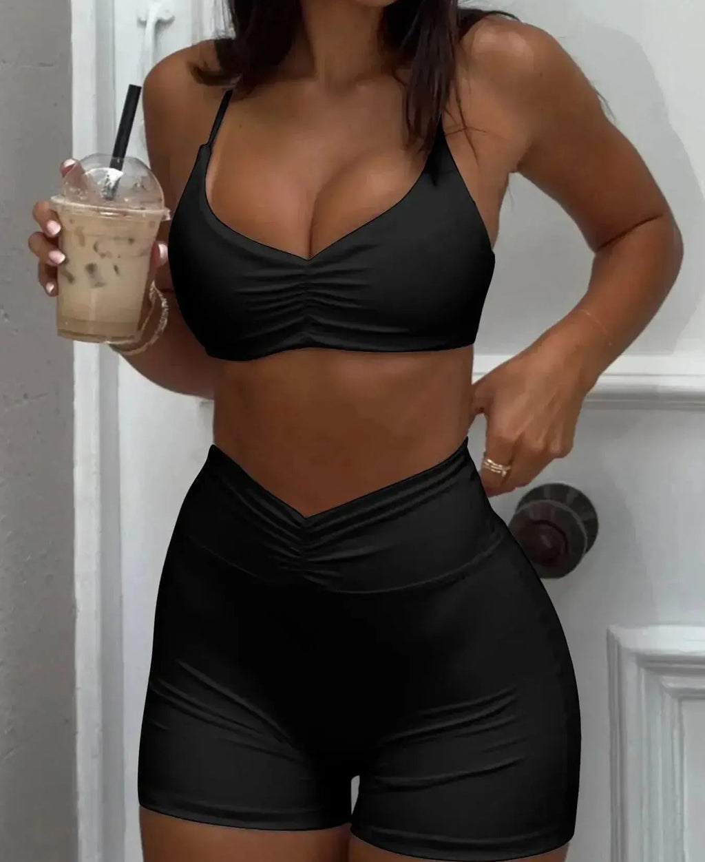 Women’s ruched sports bra and high-waisted shorts matching activewear set by Trendsi, featuring comfortable, stylish workout clothing.