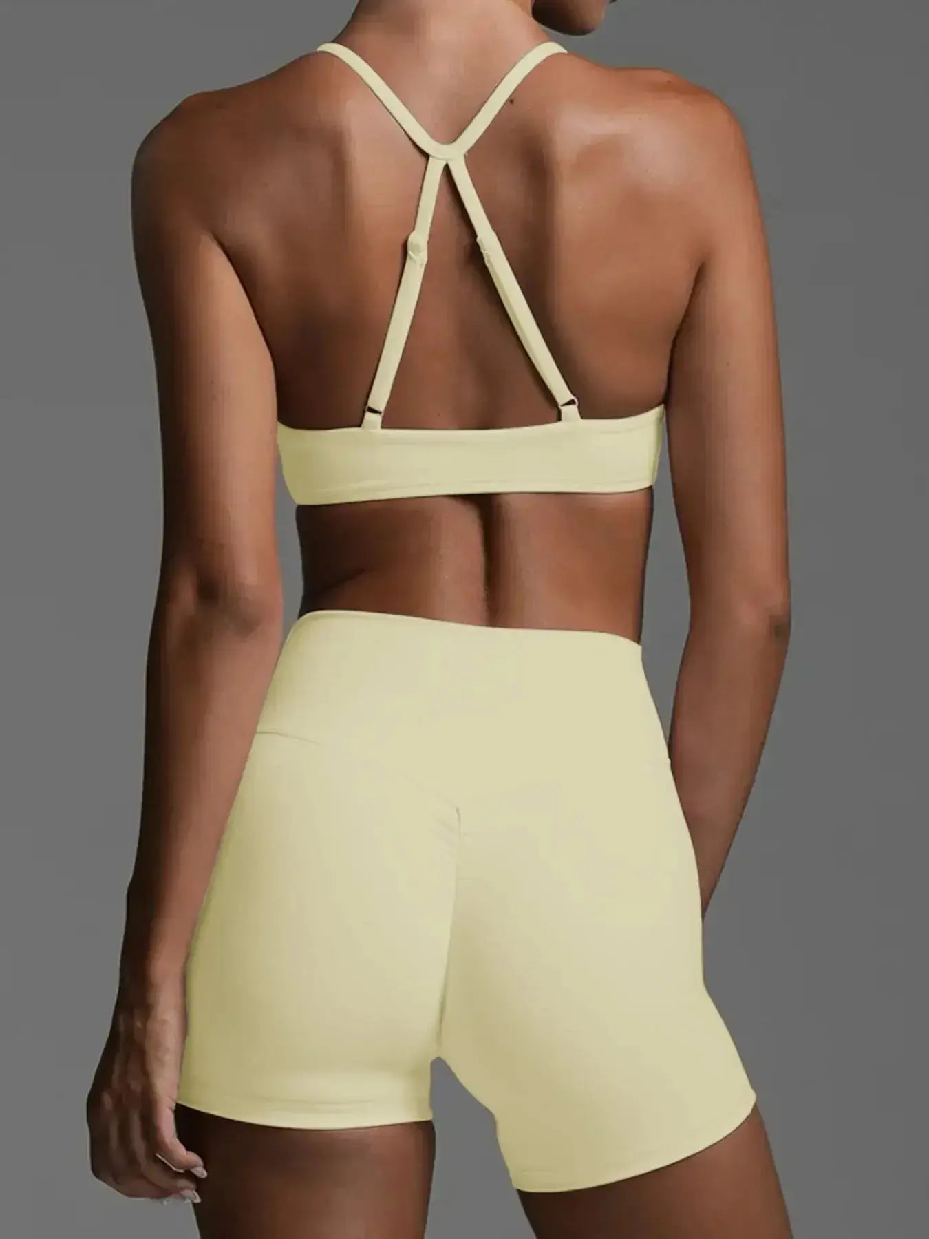 Women wearing a trendy ruched sports bra and high-waisted shorts activewear set by Trendsi, perfect for workout or casual wear.
