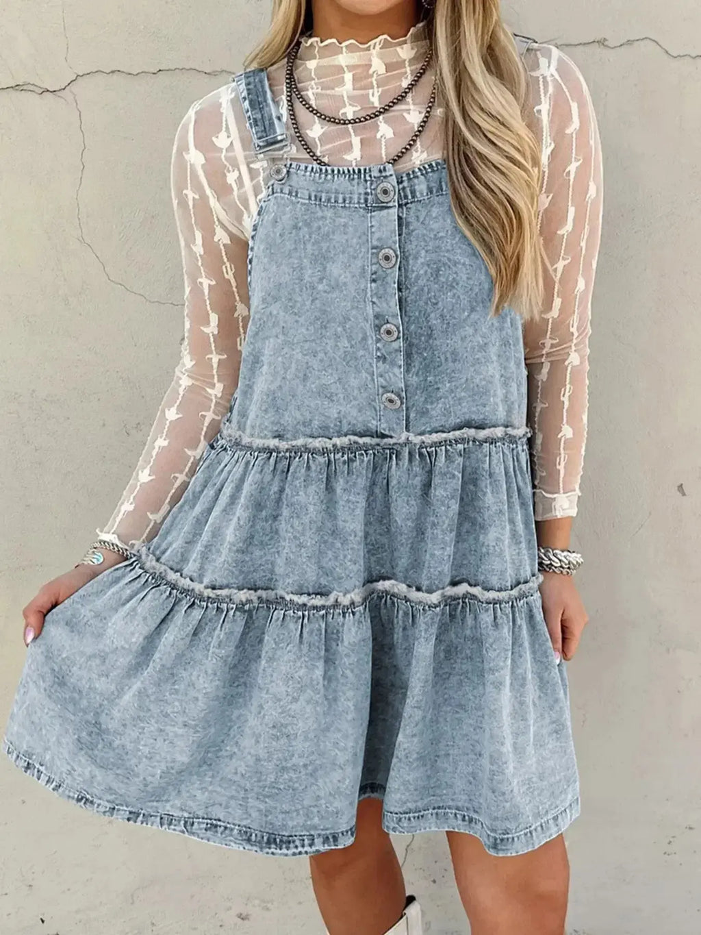 Women’s tiered flowy denim overall dress with raw hem, made of 100% cotton, featuring a relaxed fit and casual style.