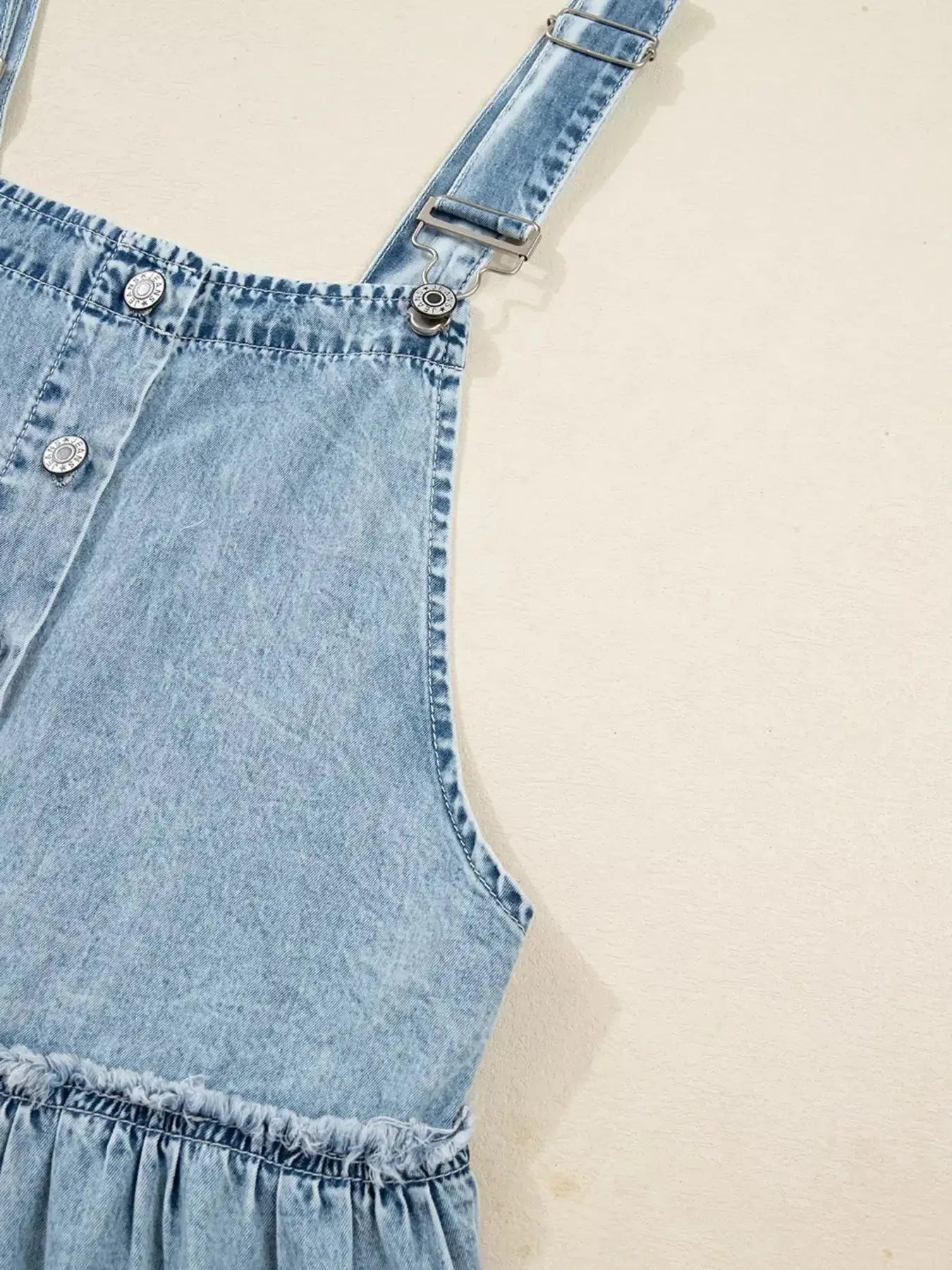 Women’s tiered flowy denim overall dress with raw hem, made of 100% cotton, featuring adjustable straps and casual style.