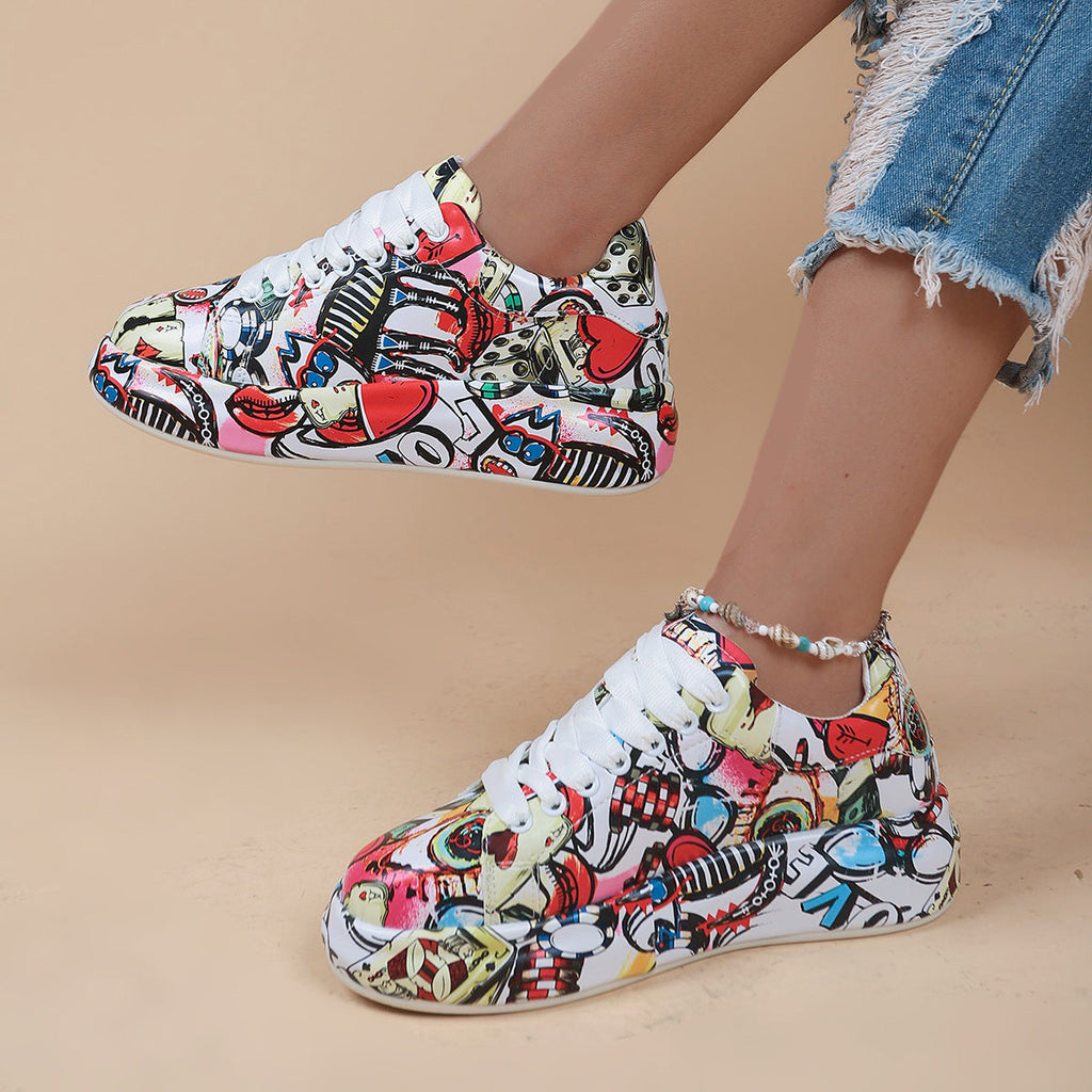 Low-top sneakers with a vibrant, multicolor graffiti print, white laces, and thick platform soles.