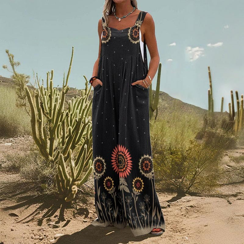Woman wearing a black, wide-leg sleeveless jumpsuit with a sunflower print and side pockets in a desert setting.