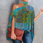 Blue and green paisley-print choker-neck top with gold-tone hardware on one shoulder and a brown clutch.