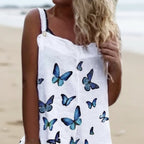 White sleeveless linen-blend dress with blue butterfly print, scoop neck, and button detail on the strap.
