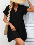 Lightweight plaid V-neck mini dress with ruffle hem by Trendsi, perfect for seasonal fashion and casual occasions.