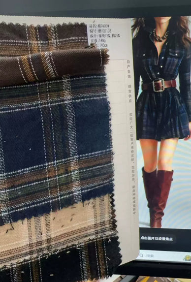 Fabric swatches of navy and tan plaid next to a model wearing a navy plaid shirt dress with a brown belt and boots.