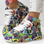 Platform sneakers with a colorful, vibrant pop-art comic print, white laces, and a floral ankle bracelet.