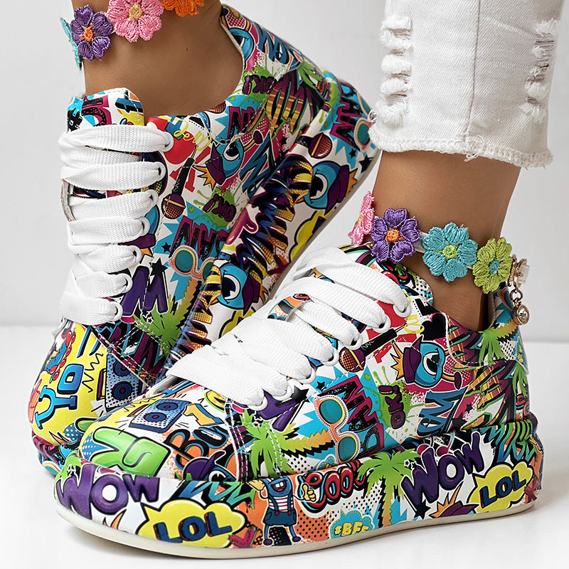 Platform sneakers with a colorful, vibrant pop-art comic print, white laces, and a floral ankle bracelet.