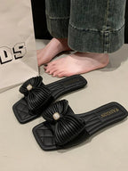Women's elegant faux leather flat sandals with bow-knot detail, featuring a stylish and comfortable design from Trendsi.