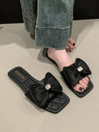 Women's elegant bow-knot faux leather flat sandals with open toes and ankle straps, stylish and comfortable for summer wear.